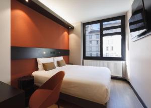リヨンにあるホテル ドゥ ノアイユのベッドと窓が備わるホテルルーム