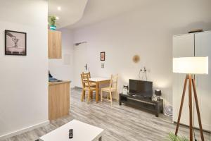 a living room with a kitchen and a table with chairs at Blue Chili Apartments Prenzlauer Berg in Berlin