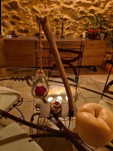 um quarto com uma mesa e uma cadeira com uma vela em Chambre d'hôte la Coquierrerie em Sottevast