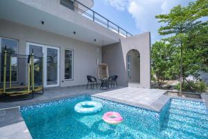 a swimming pool in front of a house at StayVista at Sukoon with Bonfire in Lucknow