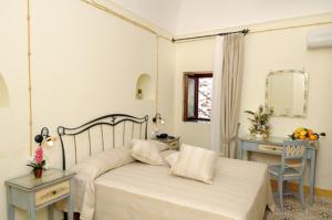 a bedroom with a bed and a table and a mirror at Locanda Degli Dei in Praiano