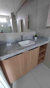 a bathroom with a sink and a mirror at Residencial Taormina - apartamento à beira-mar novinho! in Tamandaré