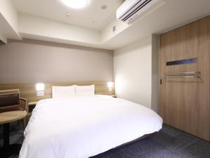 Ένα ή περισσότερα κρεβάτια σε δωμάτιο στο Dormy Inn Hiroshima Annex