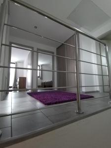 Habitación con pared de cristal y alfombra morada. en Ubytovanie v súkromí Horec, en Liptovský Mikuláš