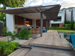 a wooden deck with a wooden pergola at Studio 2 The Waterclub in Rivière Noire