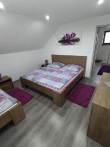 a bedroom with a bed and purple rugs at Ubytovanie v súkromí Horec in Liptovský Mikuláš