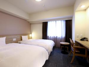 Ένα ή περισσότερα κρεβάτια σε δωμάτιο στο Dormy Inn Hiroshima Annex