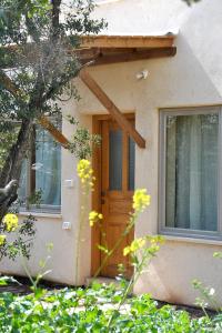 een huis met een houten deur en een raam bij בית האלה Home of Ela in Abirim