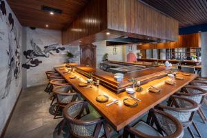 a long wooden table in a restaurant with chairs at Aksari Resort Ubud by Ini Vie Hospitality in Tegalalang