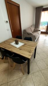 GiòHome - best apartment في غرادو: طاولة خشبية في غرفة معيشة مع أريكة