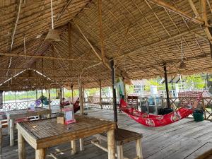 un padiglione con tavoli e amache su una terrazza in legno di Thmorda Riverview Resort a Koh Kong