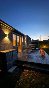 um deque de madeira com um banco e uma mesa de piquenique em ULU House With Terrace & Hot Tub em Mārupe