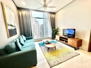 sala de estar con sofá y TV en Soho Suites klcc by i.desk, en Kuala Lumpur