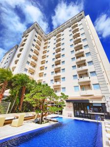 a hotel with a swimming pool in front of a building at Hotel Palm Royal Naha Kokusai Street in Naha