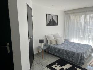 1 dormitorio con cama, ventana y mesa en Le Massilia, en Marsella