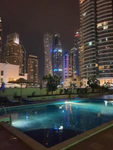 ein großes Schwimmbad in einer Stadt in der Nacht in der Unterkunft Comfort Place, Dubai Marina, City skylines. in Dubai