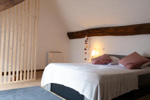sypialnia z dużym łóżkiem z drewnianym zagłówkiem w obiekcie Appartement au Centre ville historique Le vieux Langres w mieście Langres