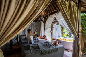eine Gruppe von drei Männern in einem Schlafzimmer mit Badewanne in der Unterkunft Aksari Resort Ubud by Ini Vie Hospitality in Tegalalang
