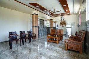 uma sala de jantar com cadeiras de madeira e uma mesa em Selva Inn em Pondicherry