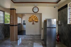 a room with a refrigerator and a clock on the wall at Selva Inn in Puducherry