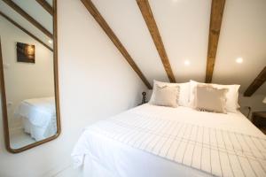 - une chambre avec un lit blanc et un miroir dans l'établissement Fisherman's house La Pineta, à Murter