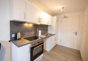 a kitchen with white cabinets and a stove top oven at City Appartement Küche,Bad, Parken im Zentrum von Ravensburg in Ravensburg