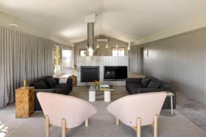 a living room with black furniture and a fireplace at Carrajung Estate in Willung South