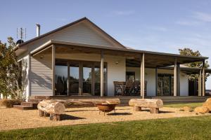 a house with two benches in front of it at Carrajung Estate in Willung South