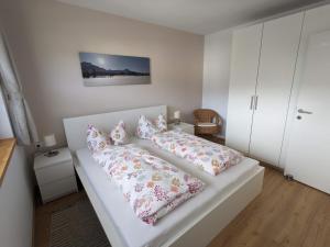 una cama blanca con almohadas en una habitación en Ferienwohnung Bergzauber, en Sankt Jakob in Haus