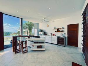 uma grande cozinha com electrodomésticos brancos e uma grande janela em VILLA TSAY - Nature, Privacy, Elegance em Haad Yao