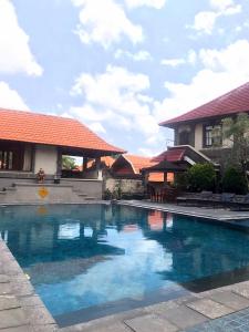a swimming pool in front of a house at Pande Permai Bungalows in Ubud