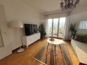 a living room with a couch and a tv and a table at Charming Penthouse near Como lake in Chiasso