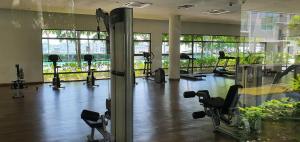 un gimnasio con varias cintas de correr y máquinas en una habitación en NC Cottage @ The Loft Imago en Kota Kinabalu