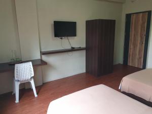a room with two beds and a tv and a chair at OYO 1011 First Hotel in Manila