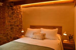 a bedroom with a bed with white sheets and two lamps at El Molino de Nocedo in León