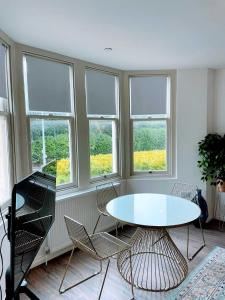 a room with a table and chairs and windows at Cardiff luxury apartment in Cardiff