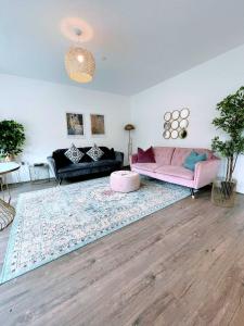 a living room with a pink couch and a rug at Cardiff luxury apartment in Cardiff