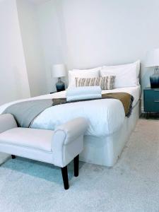 a bedroom with a white bed and a white chair at Cardiff luxury apartment in Cardiff