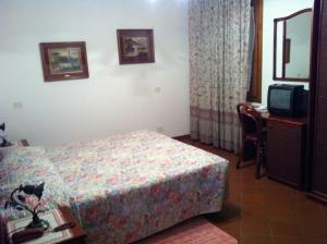 a hotel room with a bed and a tv at Agriturismo La Cavaliera in Monteveglio