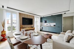 ein Wohnzimmer mit einem Tisch und einem Sofa in der Unterkunft OLYMPIADES - PATAY Beautiful apartment in Paris