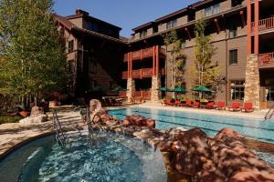 una piscina con una fuente en un complejo en The Ritz Carlton Residences Aspen en Aspen
