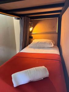 - un lit rouge et blanc avec un oreiller dans l'établissement 2street Hostel, à Surat Thani