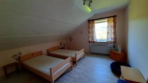 ヴィンターベルクにあるUnter den Wolkenのベッド2台と窓が備わる客室です。