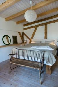 um quarto com uma cama e um banco num quarto em Gutshof Langensee em Langensee