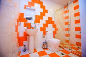 an orange and white bathroom with a toilet and shower at ART SAMARQAND HOTEL in Samarkand