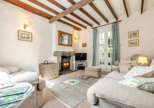 a living room with two couches and a fireplace at Dowr Penty in Helford