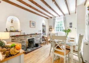 a kitchen and living room with a stone fireplace at Dowr Penty in Helford