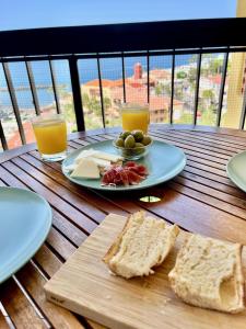 a table with a plate of bread and two glasses of orange juice at Lookout Point Tenerife Holiday Apartment Las Americas in Playa Fañabe