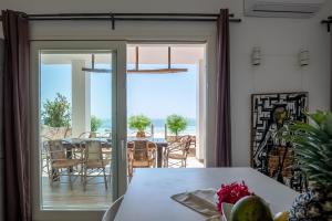 a dining room with a glass door leading to a patio at Ocean Blue Apartment with Panoramic Pool ZanzibarHouses in Kiwengwa
