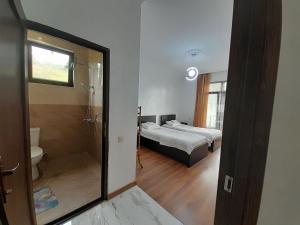 a bedroom with a bed and a bathroom with a shower at vila chakvi in Chakvi